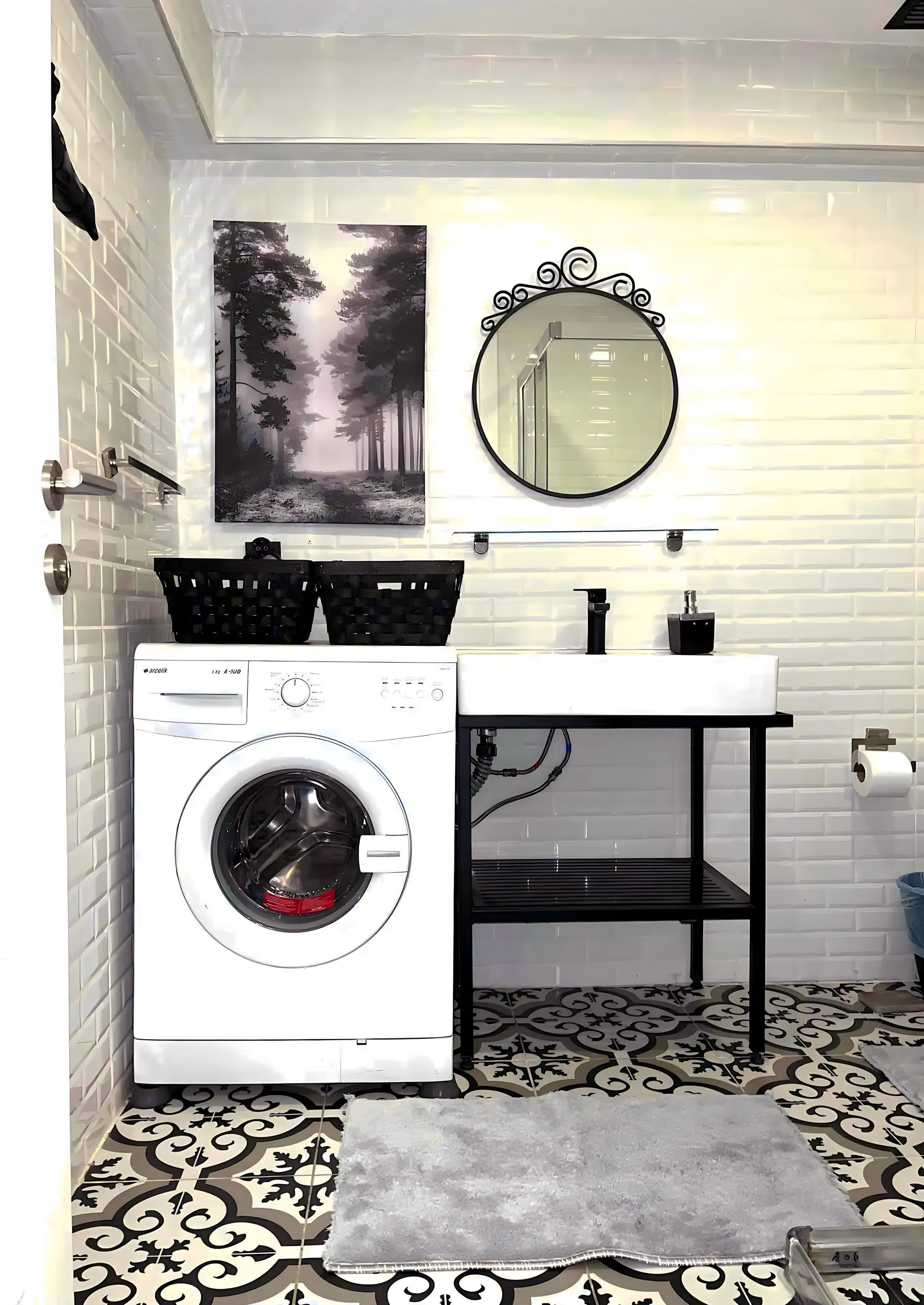 A compact laundry area with a washing machine, a sink, a mirror, and a patterned floor.