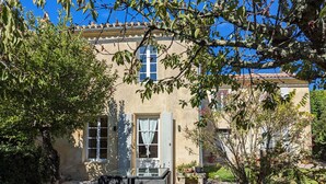 A traditional building with a stone facade, a wooden door, and a window with white shutters. - Bello Viso, Proche Saint Emilion Dans un Écrin de Verdure au Milieu des Vignes (Belvès-de-Castillon)