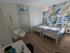 A bedroom with a bed, bedside tables, a chair, a desk, and a wall with a tropical leaf pattern. - Bello Viso, Proche Saint Emilion Dans un Écrin de Verdure au Milieu des Vignes (Belvès-de-Castillon)