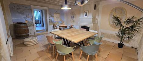 Un comedor con una mesa y sillas de madera, una planta en maceta y una chimenea.