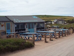 A beach house with outdoor seating and a view of the countryside.
