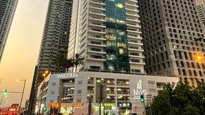 A high-rise building with a modern glass facade, surrounded by other tall buildings. - Colossal 2BR at MAG 218 Dubai Marina by Deluxe Holiday Homes (Dubai)