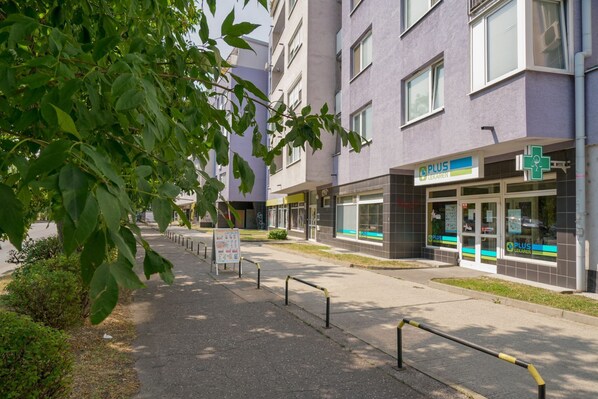 Un edificio moderno con una farmacia llamada 'Plus Lekaren' en la planta baja.