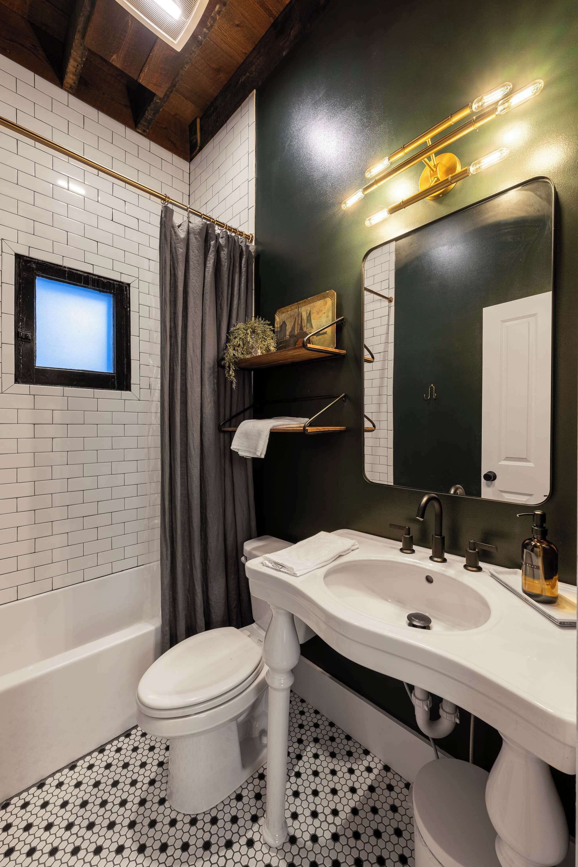 Ein Badezimmer mit Waschbecken, Spiegel, Duschvorhang und Toilette.