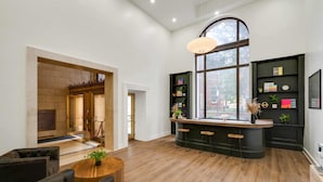 A modern interior with a bar area, seating, and a fireplace. - Sosuite | 2BR Loft w Shared W/D, Gym, Lounge (Philadelphia)