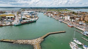 A harbor with boats, a large green ship, and industrial buildings. - Vitamin Sea - Sun Terrace Overlooking Poole Quay (Poole)