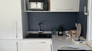 A modern kitchen with white cabinets, a black stove, and a microwave. - Villasimius Villa Mediterranean Sea... TOP!!! (Simius)