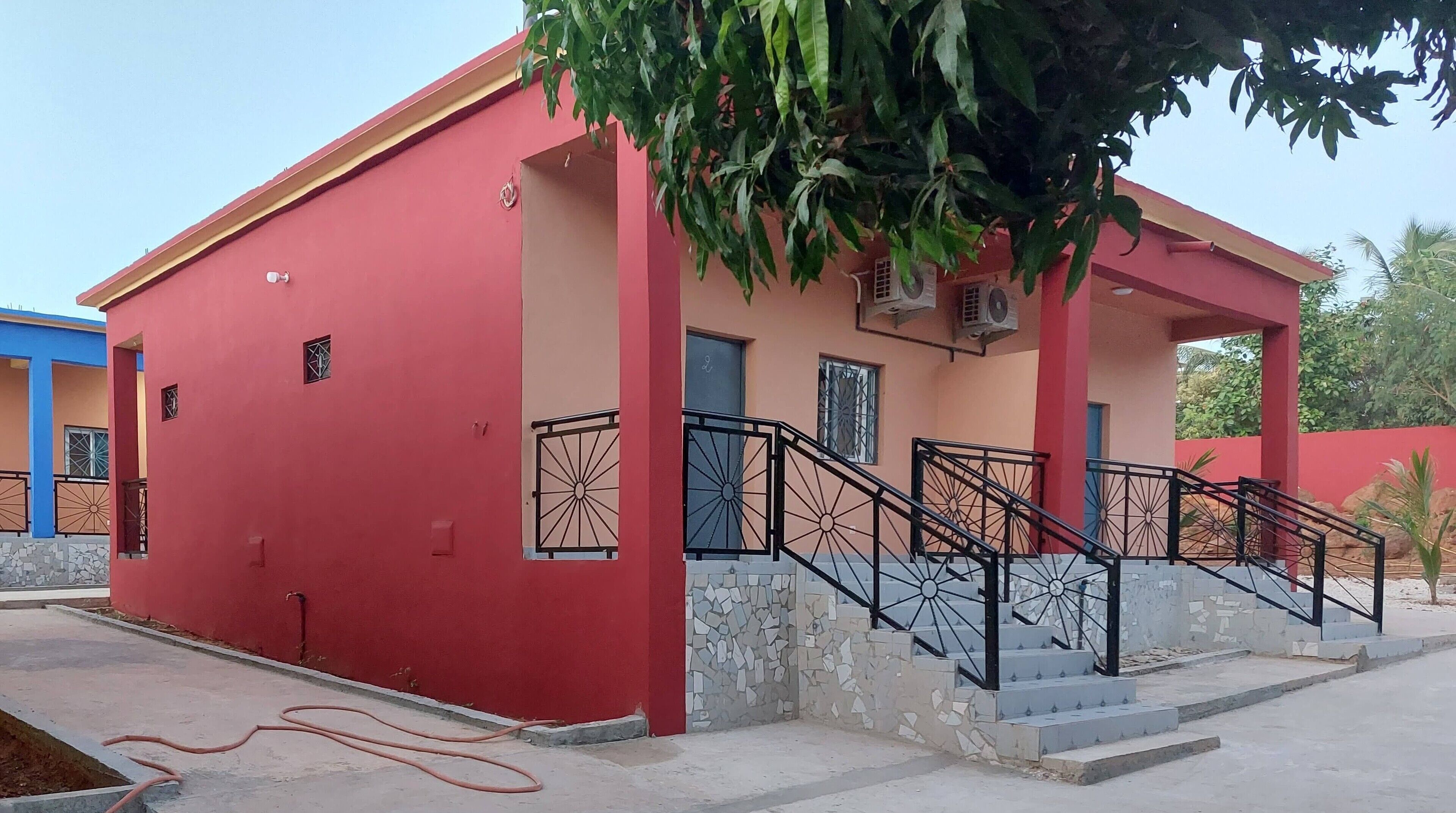 A red building with a covered porch and a staircase.