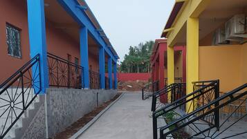 A building with blue and yellow exterior walls, a concrete pathway, and metal railings.