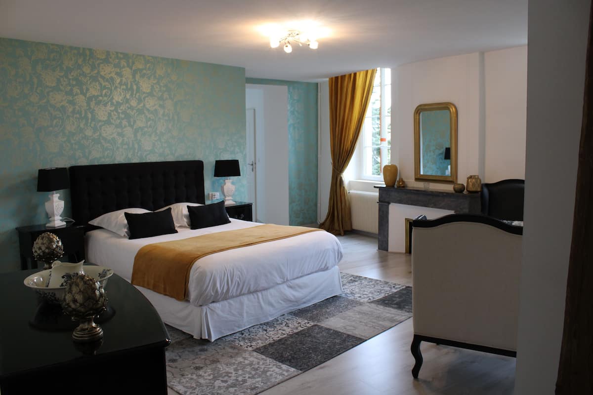 Ein Hotelzimmer mit einem großen Bett, Nachttischen, einem Schminktisch und einem Spiegel.