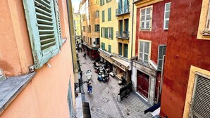A narrow street with colorful buildings, a visible restaurant, and a few pedestrians. - Elegant flat with AC, heart of Nice (Nice)