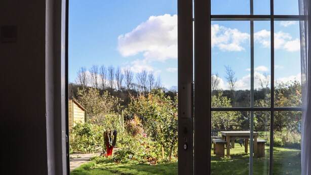 A view through a window with a garden and a wooden structure in the background. - NEWTOWN LODGE, pet friendly in Duncannon, County Wexford (Duncannon)