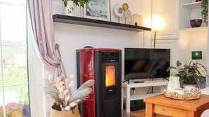 A cozy living room with a red and black wood stove, a television, and a colorful rug. - NEWTOWN LODGE, pet friendly in Duncannon, County Wexford (Duncannon)