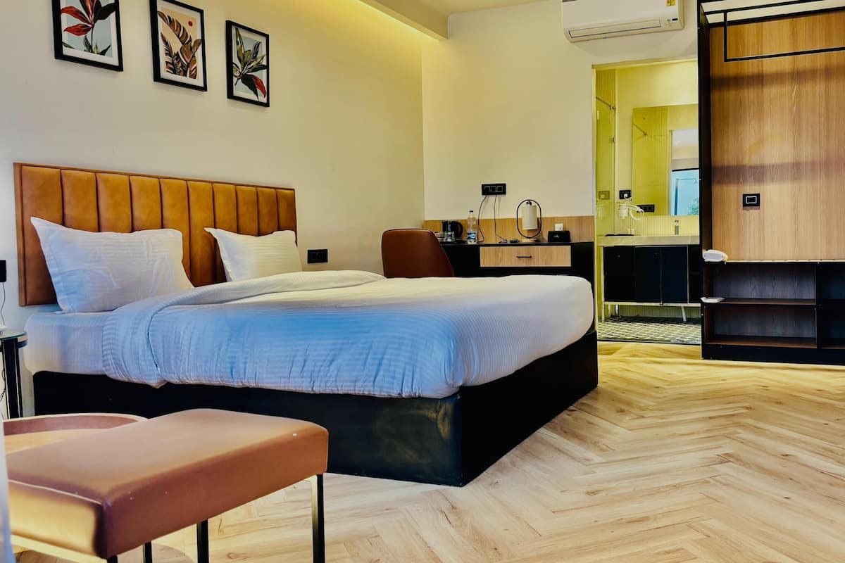 Een moderne hotelkamer met een groot bed, een bureau, een stoel en een kledingkast.