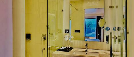 A modern bathroom with a glass shower enclosure, a sink with a vanity, and a large mirror.