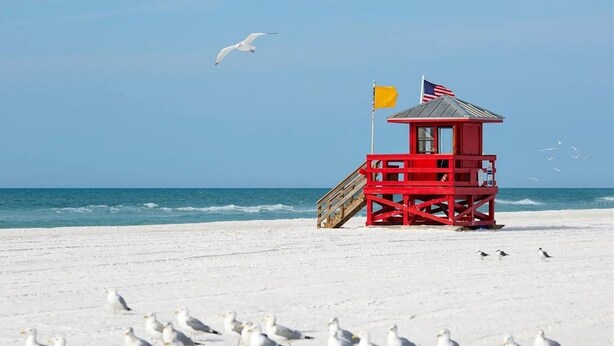 Une tour de surveillance des sauveteurs sur une plage, avec un ciel dégagé.