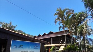 Un edificio con un grande cartello pubblicitario che recita 'Palmeiras Hospedagem Turismo' e 'Eduardo Lorens'.