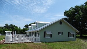 A single-story building with a gabled roof and a porch. - R/V spots on working horse farm $85 per night/$850 dollars per mo (Citra)