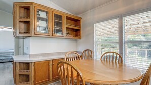 A kitchen with wooden cabinets, a white countertop, and a dining table with chairs. - 4 Mi to State Park: Peaceful Rockport Home w/ Yard (Rockport)