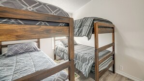 A bunk bed with a wooden frame and gray bedding. - 4 Mi to State Park: Peaceful Rockport Home w/ Yard (Rockport)