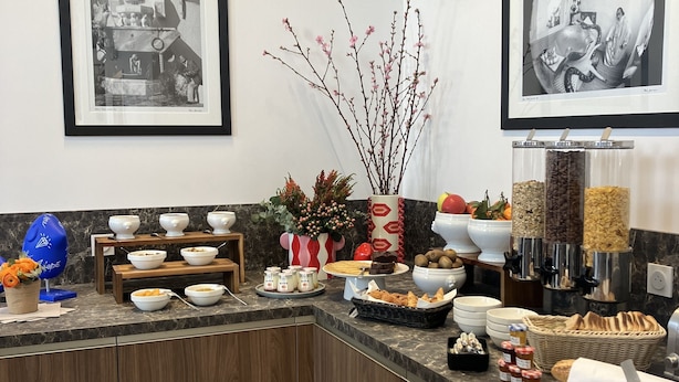 A well-organized buffet area with various food items and a decorative vase.