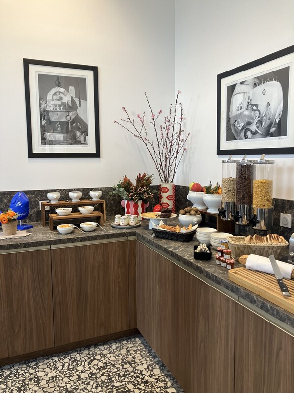 A well-organized buffet area with various food items and a decorative vase. - Dali Hôtel Montauban (Montauban)