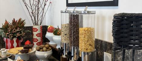 A buffet setup with various food items, a framed picture on the wall, and a marble countertop.