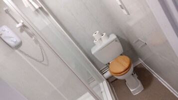 Een badkamer met toilet, douche en handdroger.