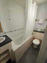 Un baño con bañera, inodoro y lavabo.