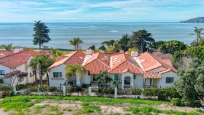 Una zona residenziale costiera con case dai tetti rossi e pareti bianche, immersa nel verde e con vista sull'oceano.