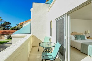 Enjoy a balcony with a glass table and two chairs, offering a clear view of the adjacent bedroom.