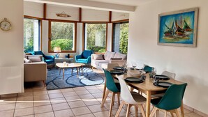 Un comedor moderno con una mesa de madera, sillas color turquesa y vistas al exterior.
