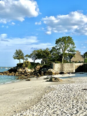 A beach with a stone wall, trees, and a clear sky. - Beg Meil - Seducing quiet house, beaches and shops on foot (Fouesnant)