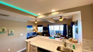 A modern kitchen with a large island, built-in appliances, and a view to the living area.