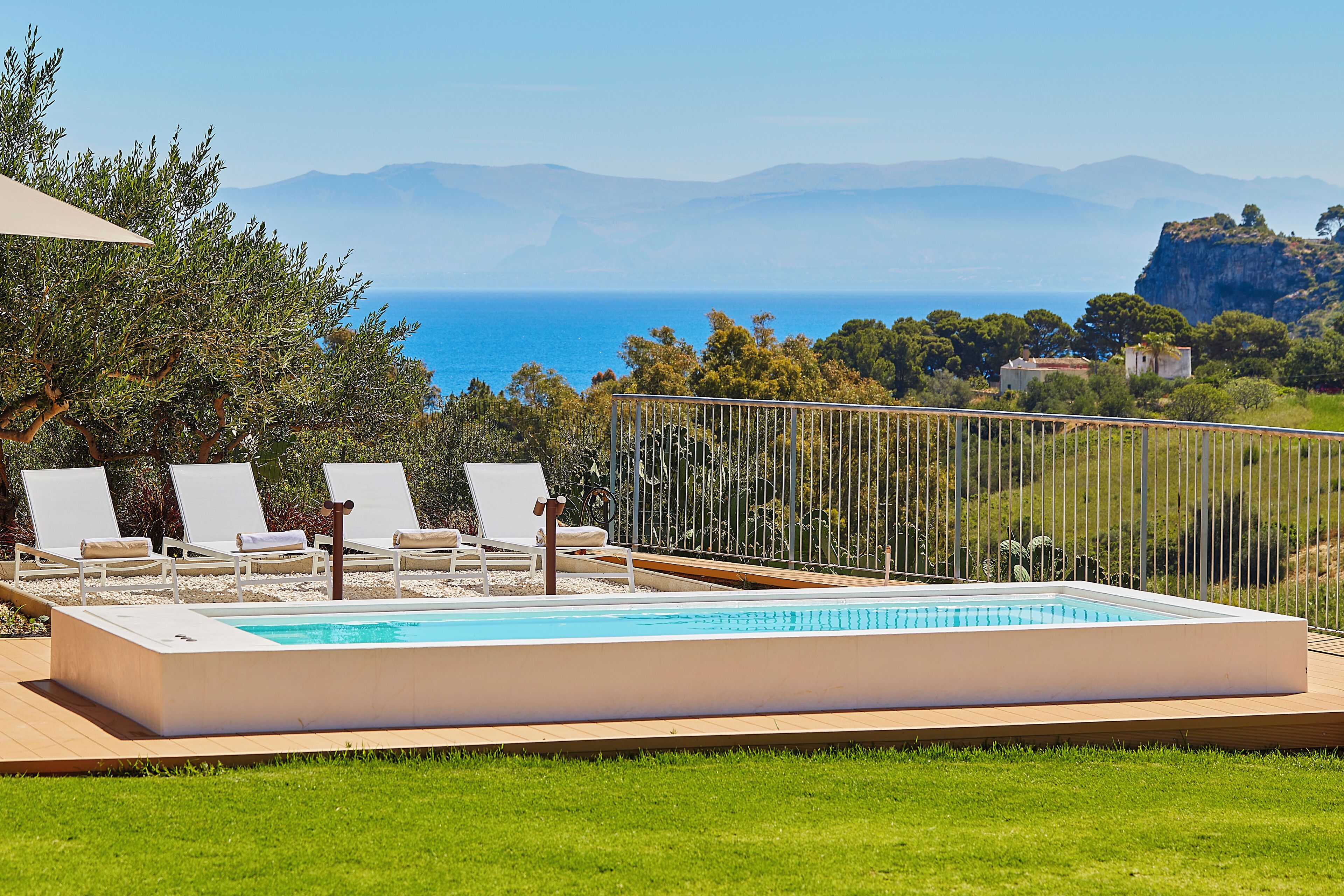 A rectangular swimming pool with a clear blue water surface, surrounded by a wooden deck.