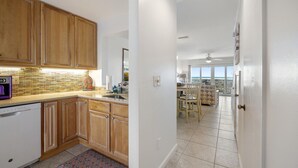 Una cocina moderna con armarios de madera, lavavajillas y salpicadero de azulejos.