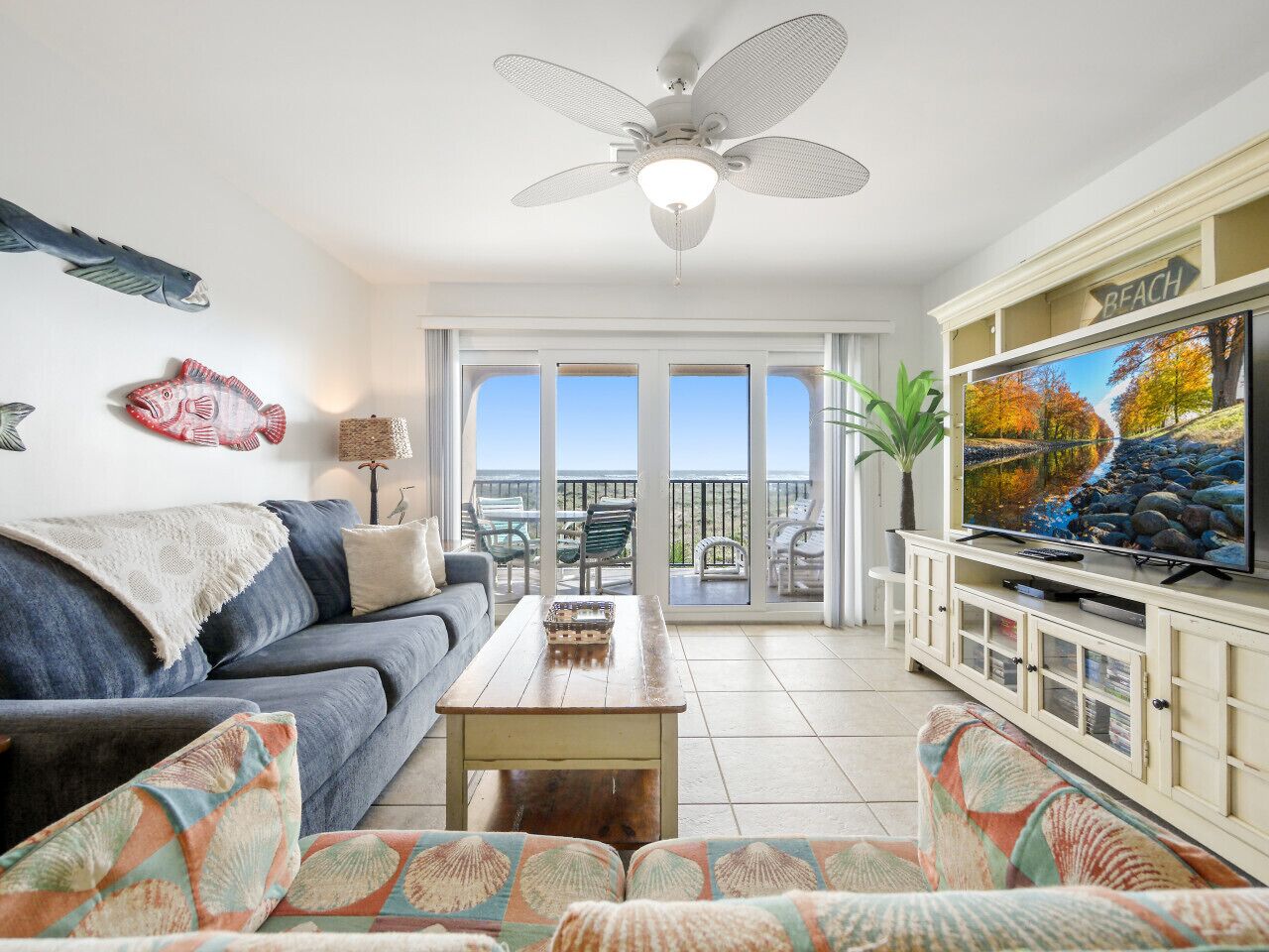 Ein Wohnzimmer mit Sofa, Couchtisch und Fernseher auf einem Balkon mit Blick.