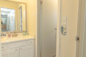 A bathroom with a white sink, mirror, and a door with a light switch and outlet. - Family fun! Perfect for families to make memories (Freeport)
