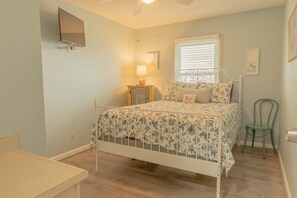 A bedroom with a bed, a chair, a nightstand, a lamp, and a wall-mounted TV. - Family fun! Perfect for families to make memories (Freeport)