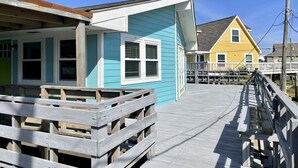 A wooden pier leading to a blue house with white trim and a yellow house in the background. - Family fun! Perfect for families to make memories (Freeport)