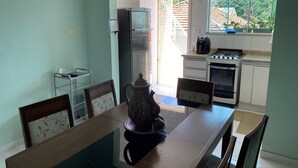 A dining area with a table, chairs, a coffee maker, and a view of the kitchen and outside. - Sobrado Tranquilo, rua Silenciosa (Jardim São Paulo São Paulo)