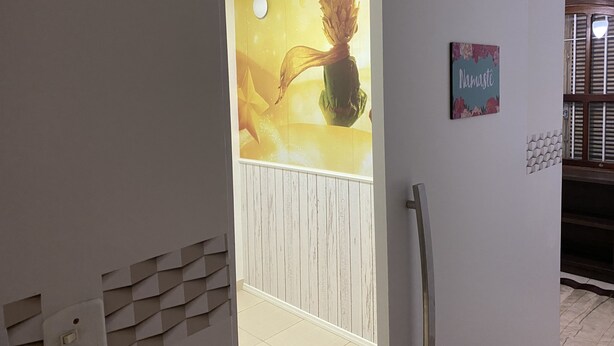 A hallway with a wall mural, a door, and a sign. - Sobrado Tranquilo, rua Silenciosa (Jardim São Paulo São Paulo)