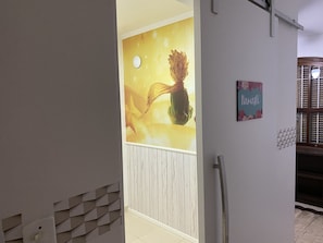 A hallway with a wall mural, a door, and a sign. - Sobrado Tranquilo, rua Silenciosa (Jardim São Paulo São Paulo)