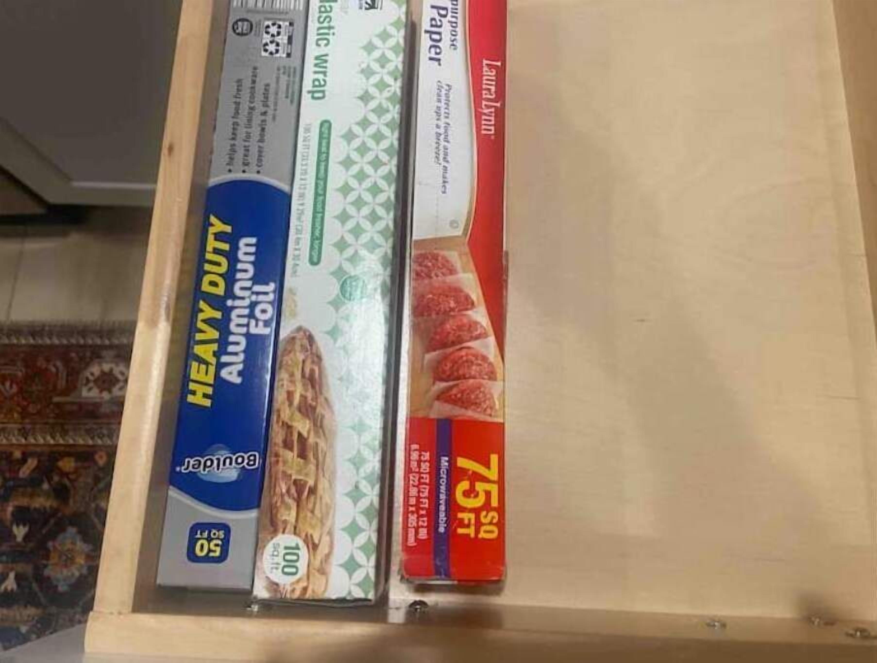 Eine Schublade mit verschiedenen Papierprodukten, darunter robuste Alufolie, Frischhaltefolie und ein 75 Quadratfuß großes Papierpaket.