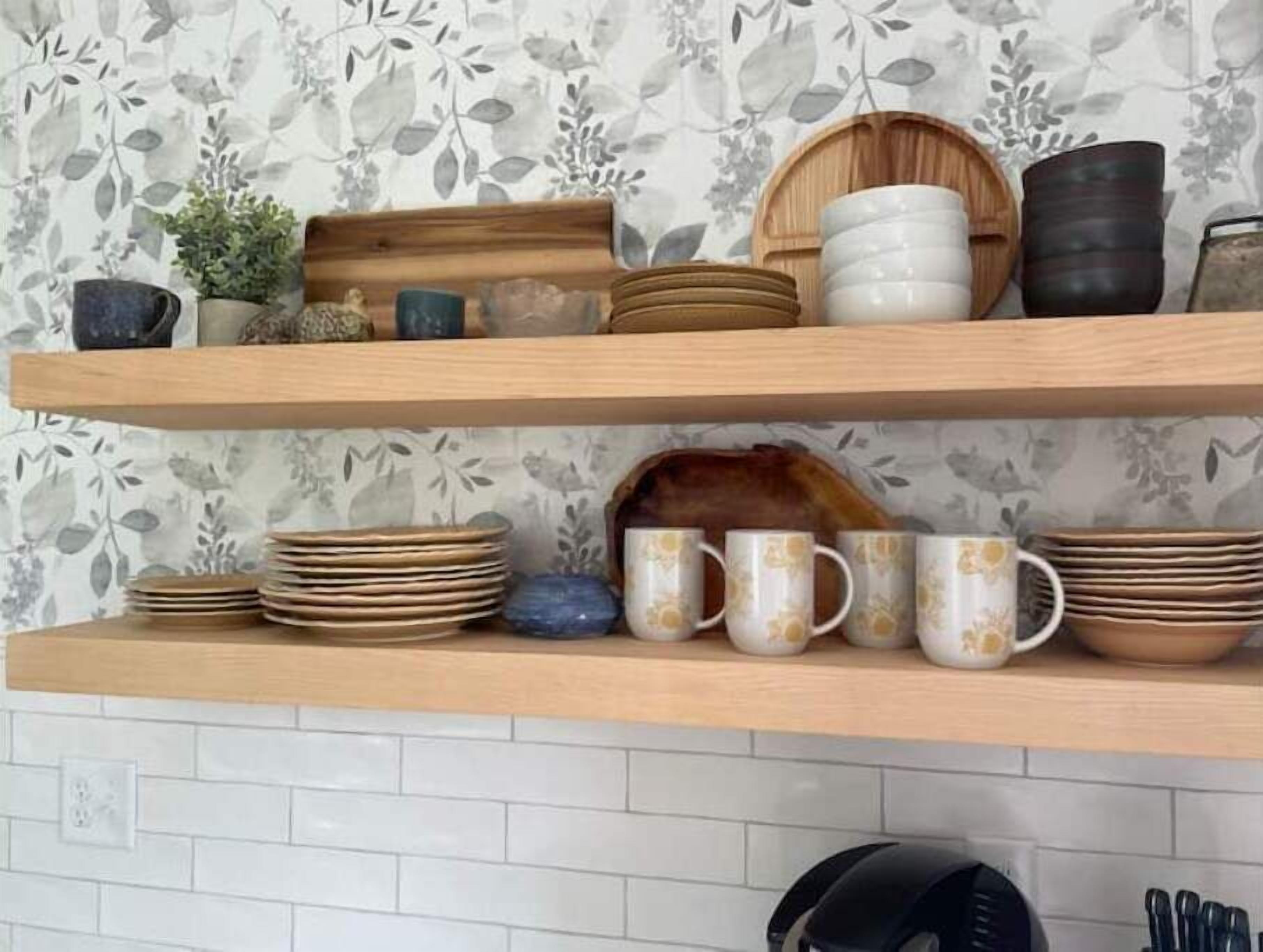 Une cuisine avec deux étagères en bois sur lesquelles sont rangés divers ustensiles de cuisine, notamment des assiettes, des bols et des tasses.