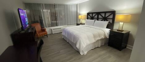 Una habitación de hotel con cama, escritorio, silla y televisión.