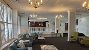 A spacious lobby with a seating area, a marble coffee table, and a staircase leading to an upper floor. - The View Hotel, Trademark Collection by Wyndham (Orlando)