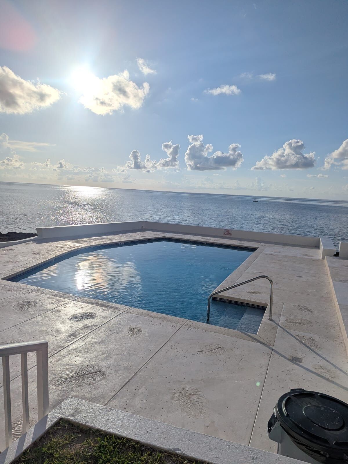 A swimming pool with a view of the sea and sky.