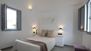 Un dormitorio moderno con una cama grande, lámparas de noche, una mesita y una ventana.