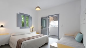 Un dormitorio con cama, mesita de noche, lámpara y vistas a través de una puerta.